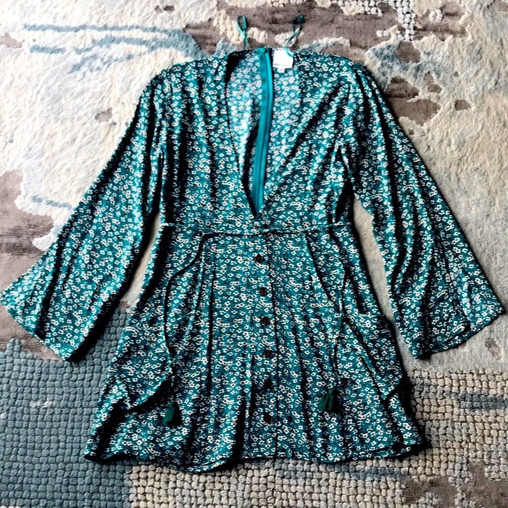 A beautiful emerald green floral print mini dress with pockets on each side.